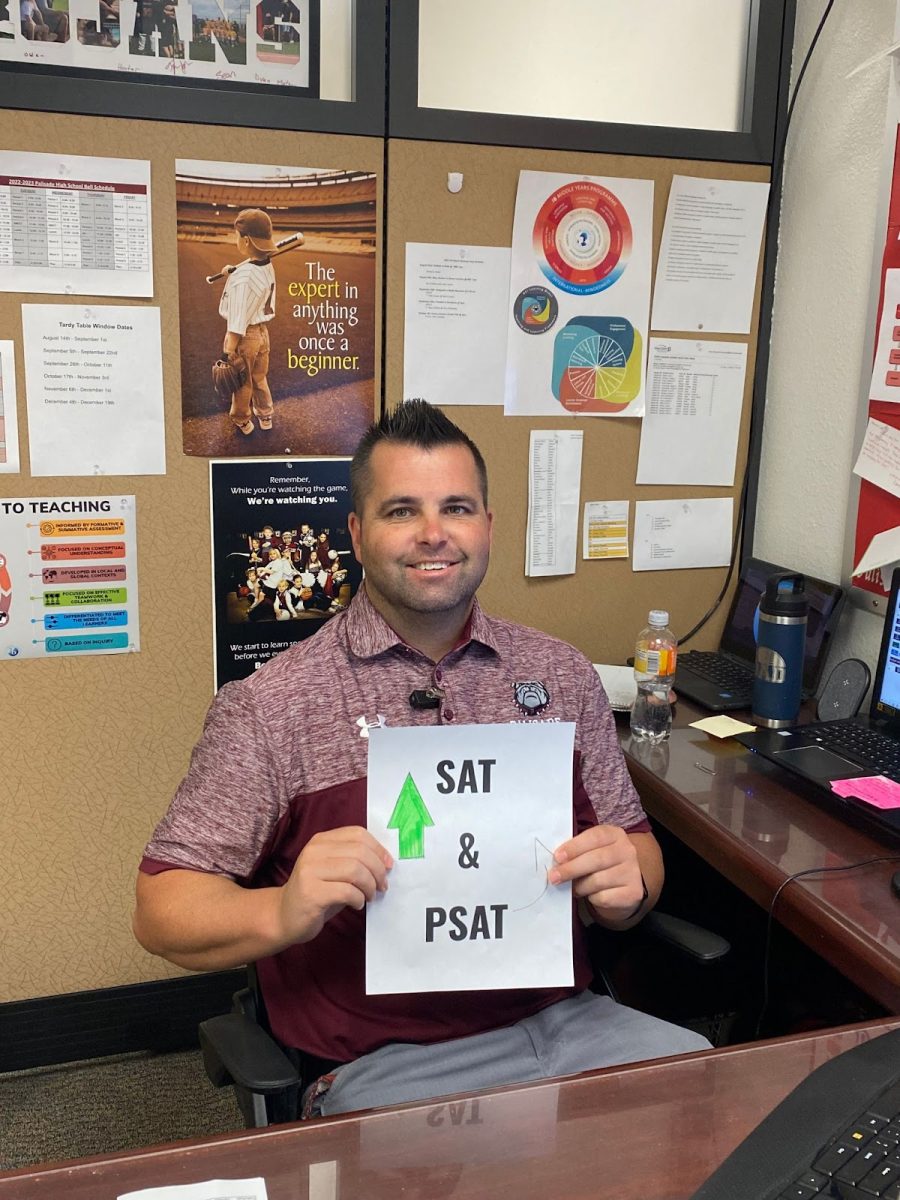 Mr. Howard holding a sign saying PSAT and SAT 