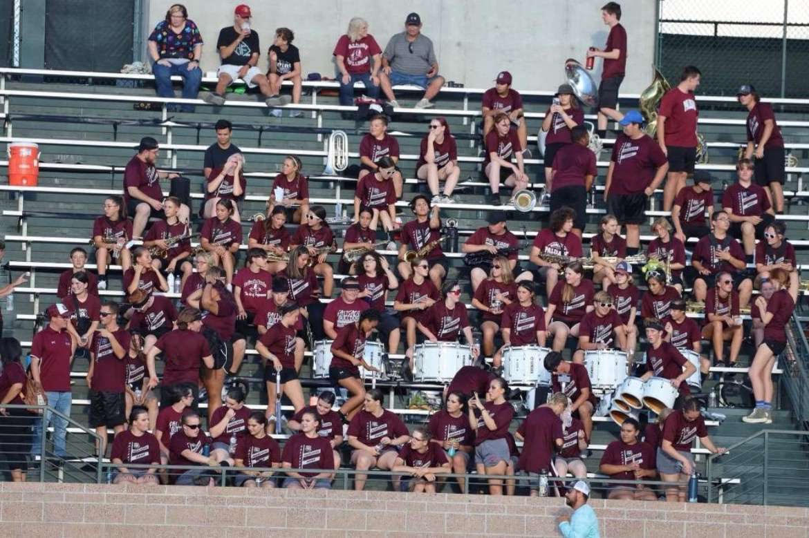 Last year’s marching band waiting in the stands during a football game to showcase the performance of a lifetime. Photo provided by Eli Jordan. 