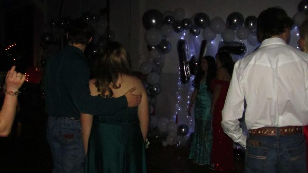 PHS Students wait to take a picture in front of the Winter Formal decoration.