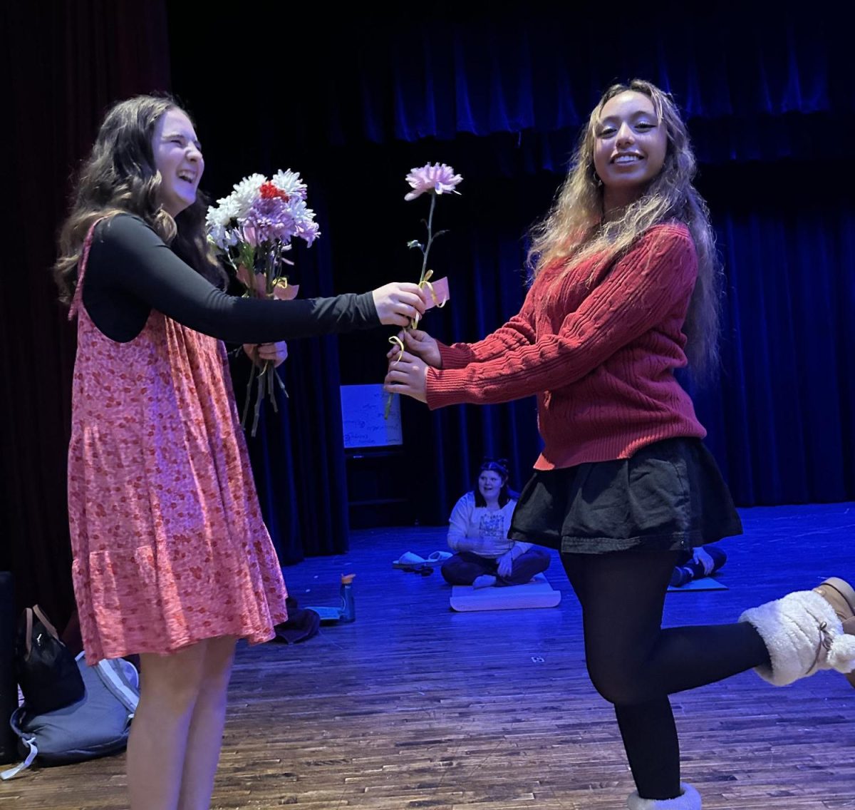 Genevive Seymour (left) handing Heidi Escobedo (right) a flower for Valentine’s Day. 