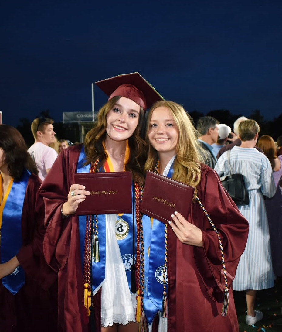 Seniors Sarah Foster and Sami MacDonald rocking their maroon caps and gowns, colorful cords, IB stoles, and diplomas. Photo provided by Sarah Foster.
