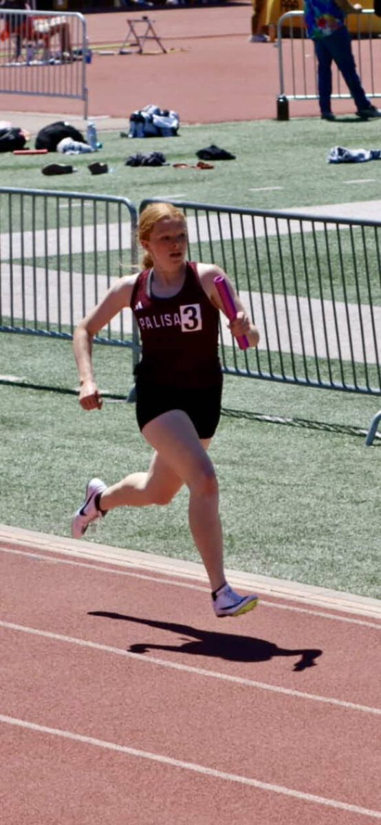 Audrie Cole running with the baton during a meet. 