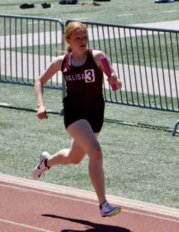 Audrie Cole running with the baton during a meet. 