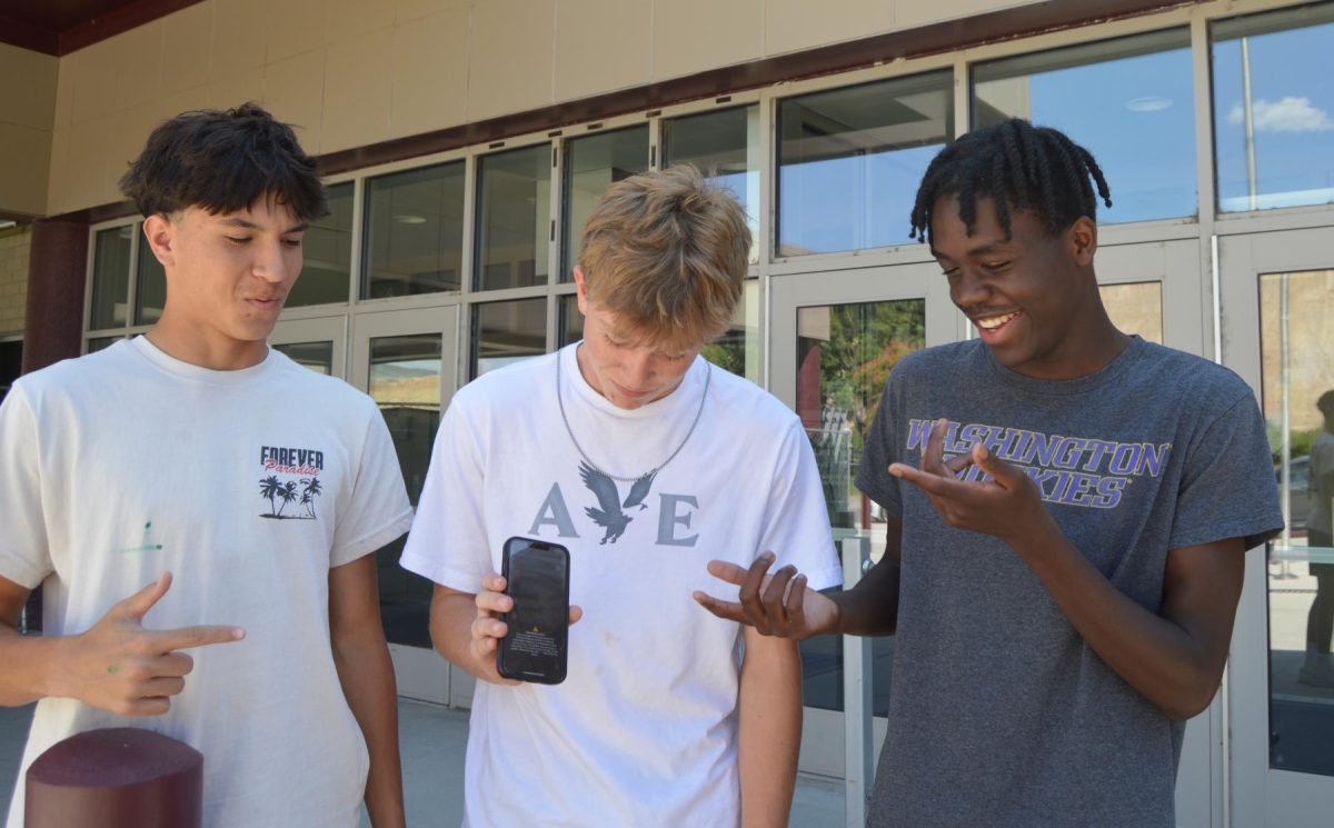 Maddox Lopez, Ryan Davis, and Jax Bavor reading the amber alert recieved on their phones. 