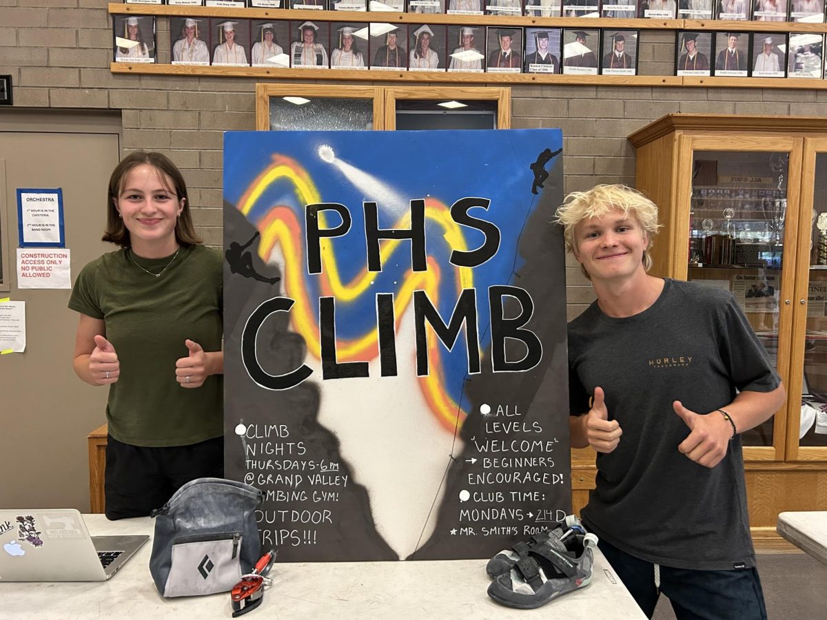 Seniors Claire Powell and Hank DeFord posing with four big thumbs up, excited for the fate of their climbing club.
