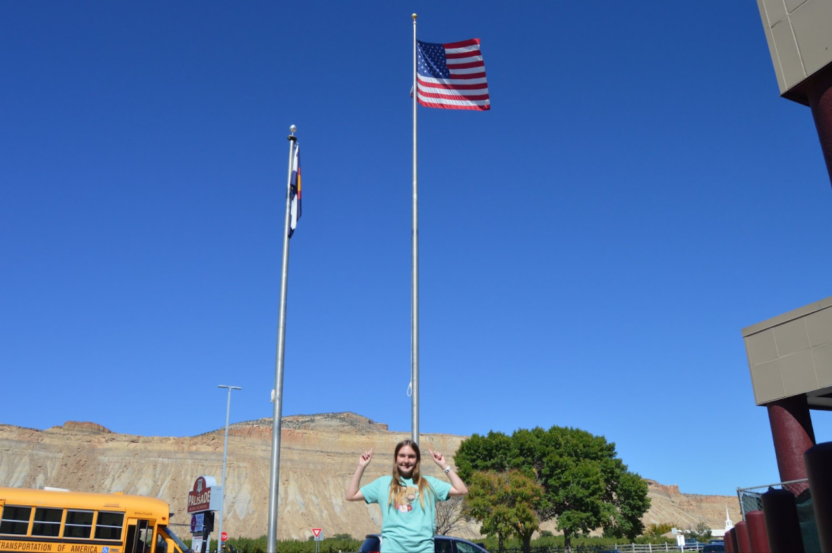 Junior Addison Stover points to the American flag.