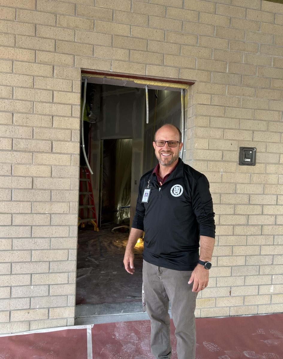 Principal Dan Bollinger, getting his photo taken standing in the location of the future security doors. 