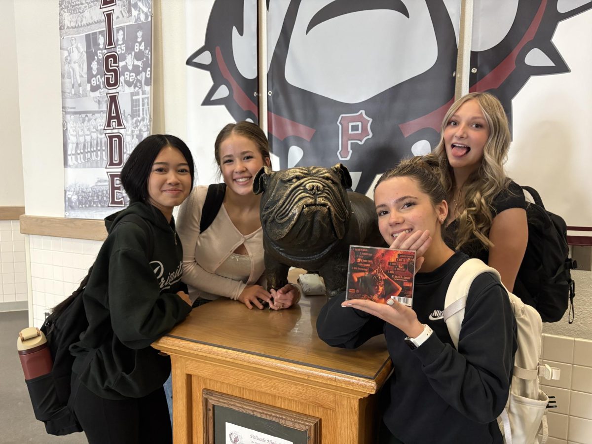 Four Sophomores Arayah Love, Hadley Fenske, Eva Grako, and Kilee Hean holding Taylor Swift's new album. 