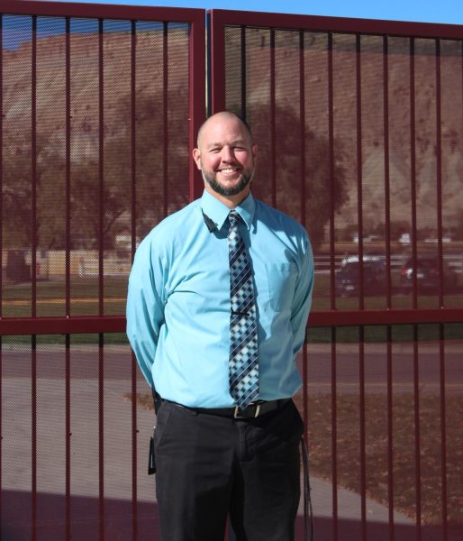 Mr. Borgman standing next to the new fence outside of Palisade High School