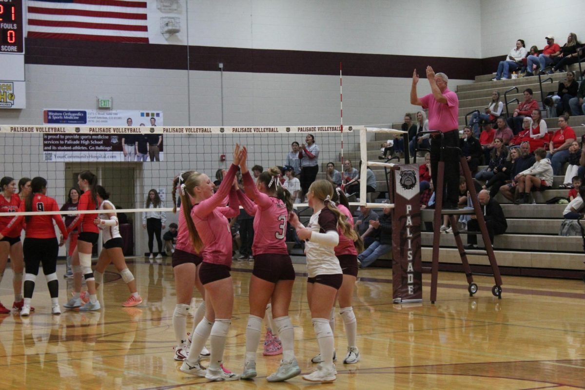 Bulldog athletes breaking out of a huddle after a play