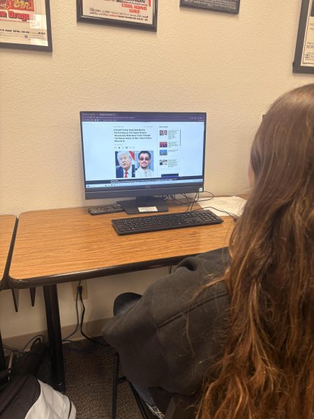 Zoey Ramsey reading the most recent updates on the Bad Bunny halftime show.