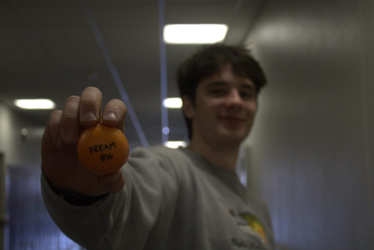 Junior Beckett Carlton poses with an imitation of an orange 'Marty Supreme' ping-pong ball.