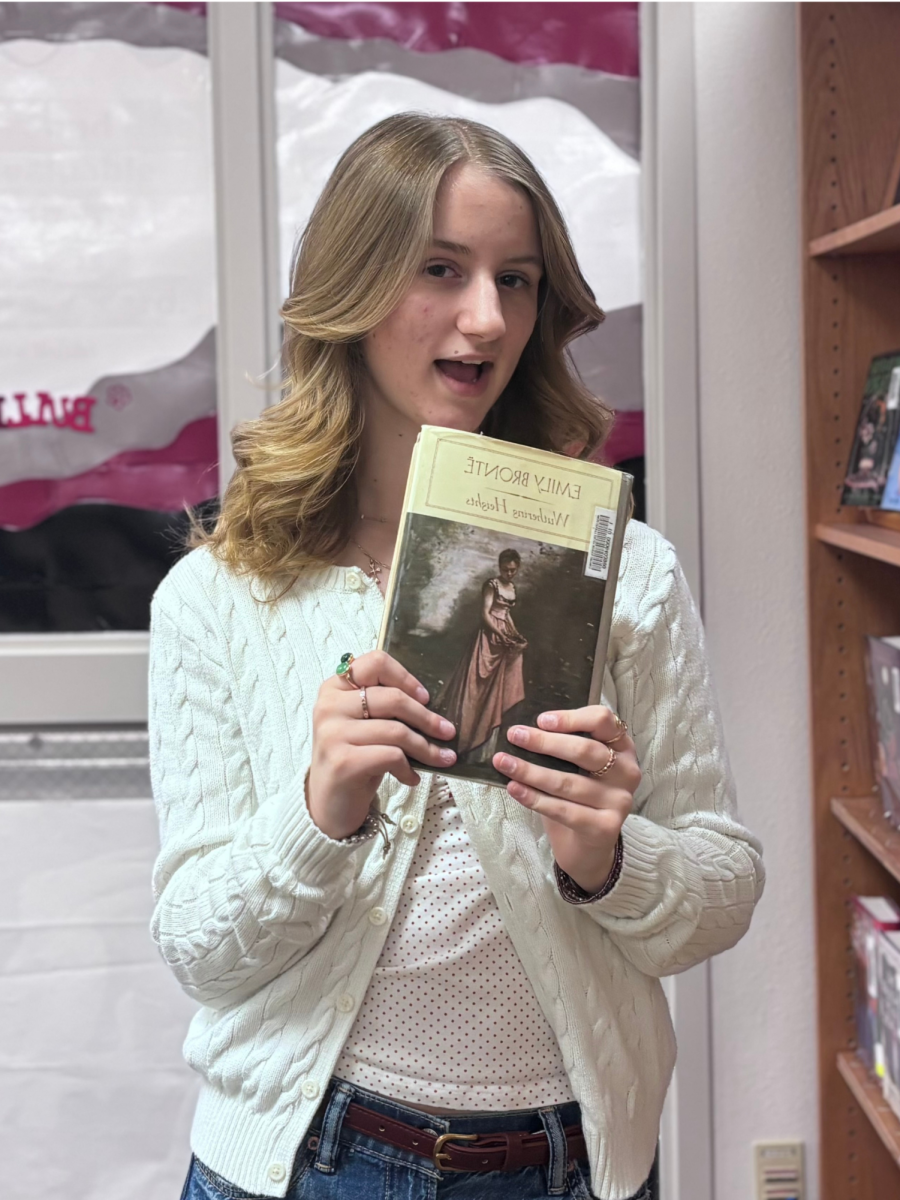 Picture Of freshman Aubrey Williams holding up the well known book Wuthering Heights soon to be made into a film adaptation.
