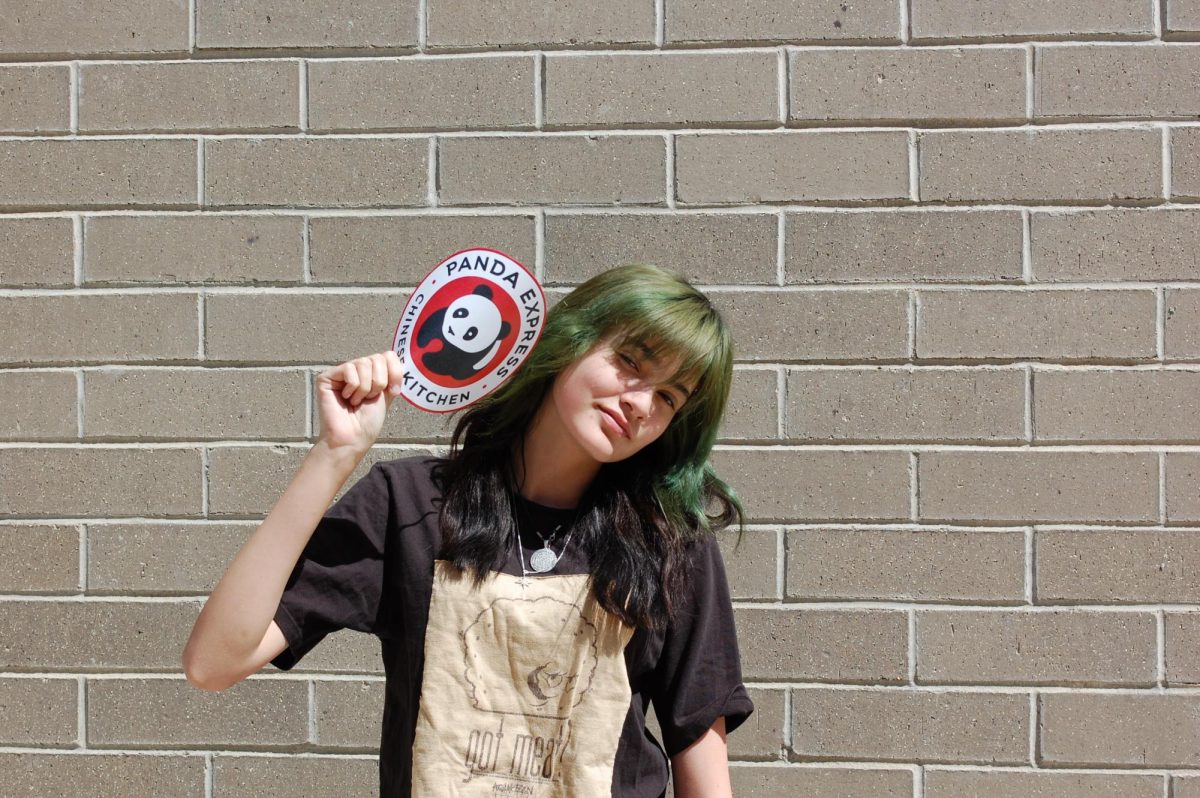 Photo of Abeyta posing with the Panda Express logo.
