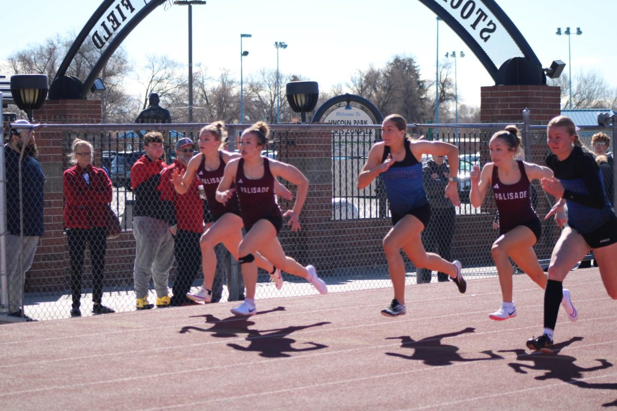 Photo of PHS girl sprinters furiously running their race. 
