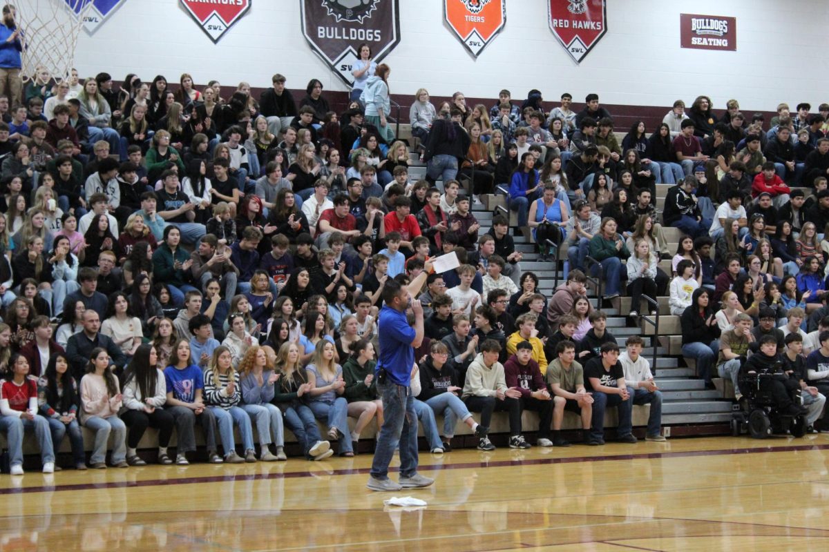 Picture Of Kids sitting at Assembly. Mr Howard speaking to the students about Winter Athletes.
