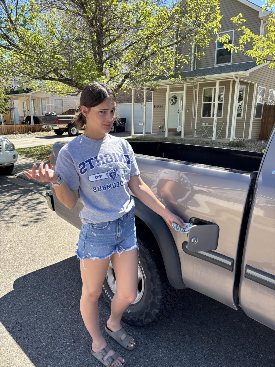 Photo of Chloe Cummings by their truck, a Grey 2000 Toyota Tundra. 
