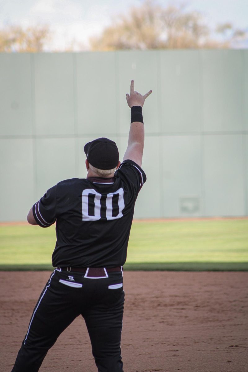 Kian Kinslow throwing a team sign to those in the out field. 