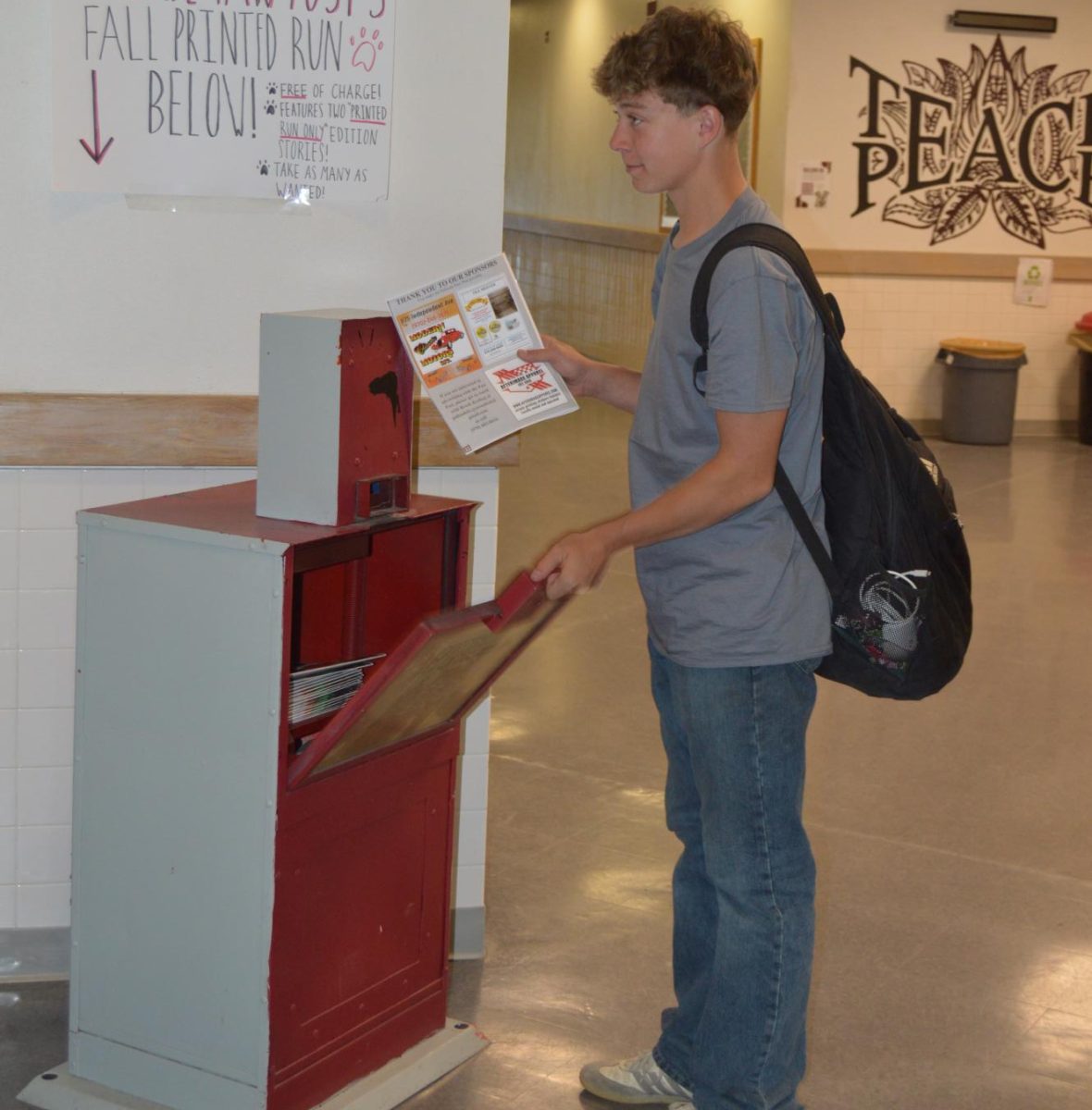 Picture of Carver Polacek taking a version of our printed run from the news box