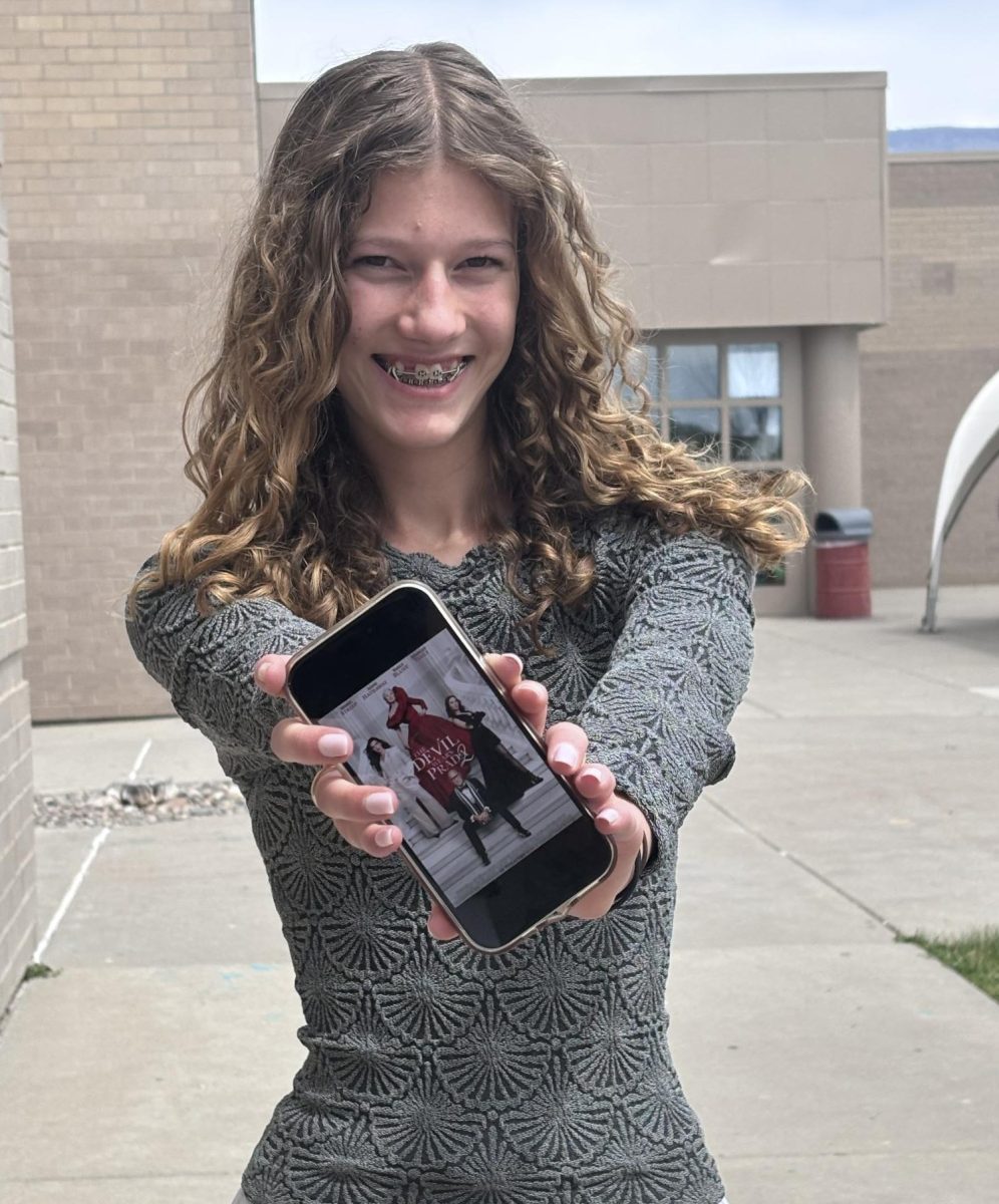  Freshman Kyra Koppelman holding up a poster for the Second New Devil Wears Prada Movie.

